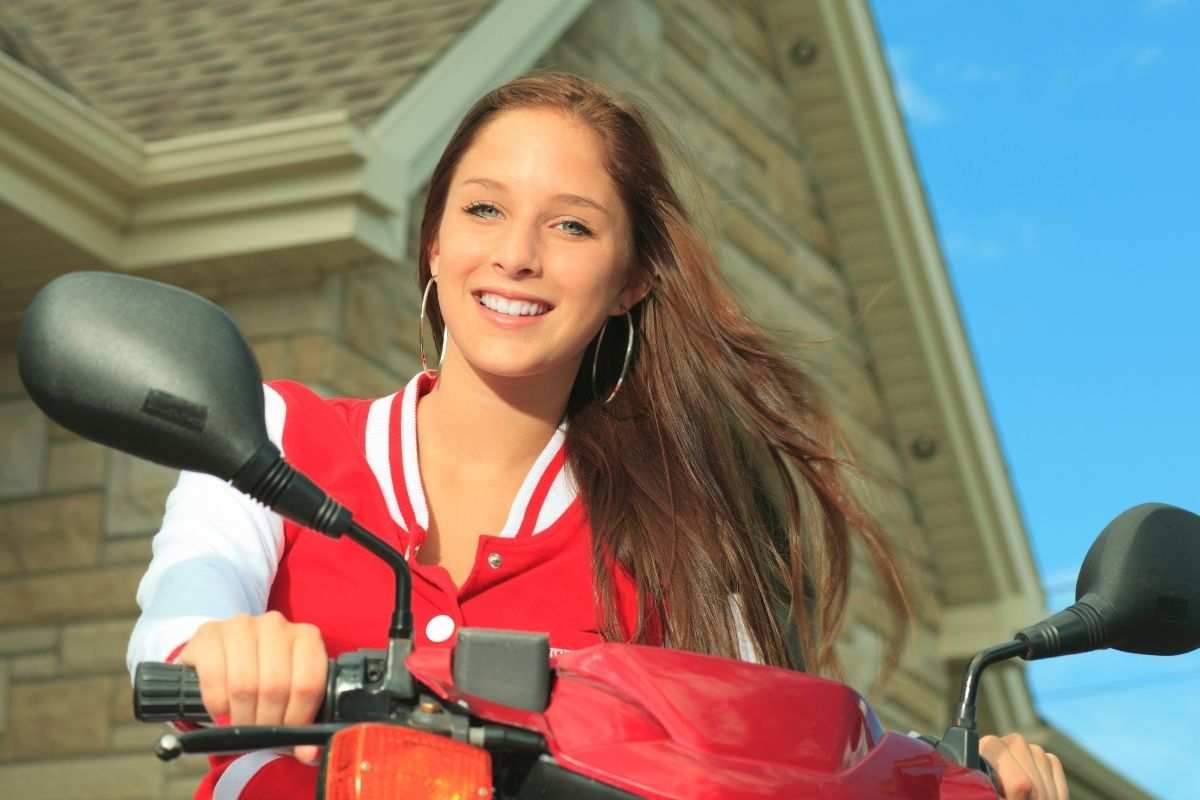 Adolescente in sella al suo scooter